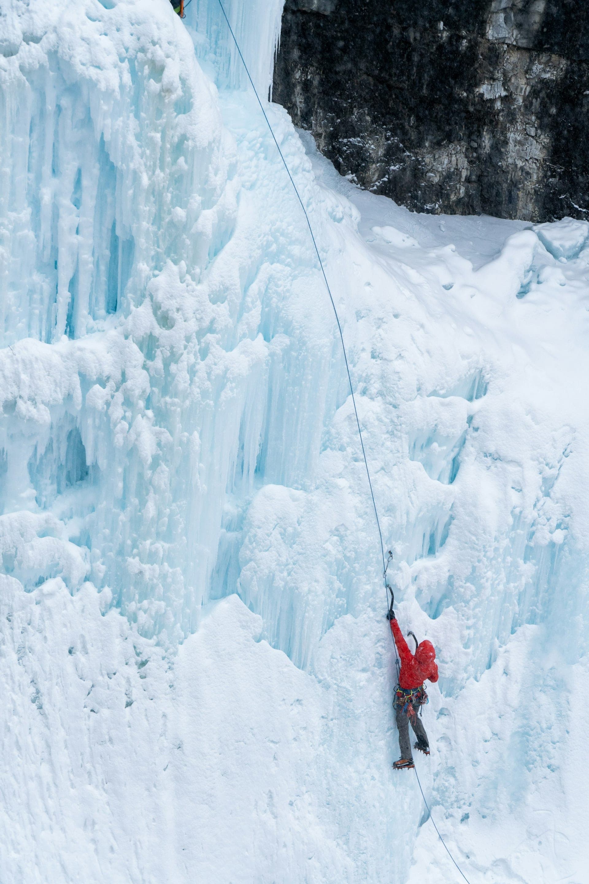 A climber scaling a frozen waterfall
